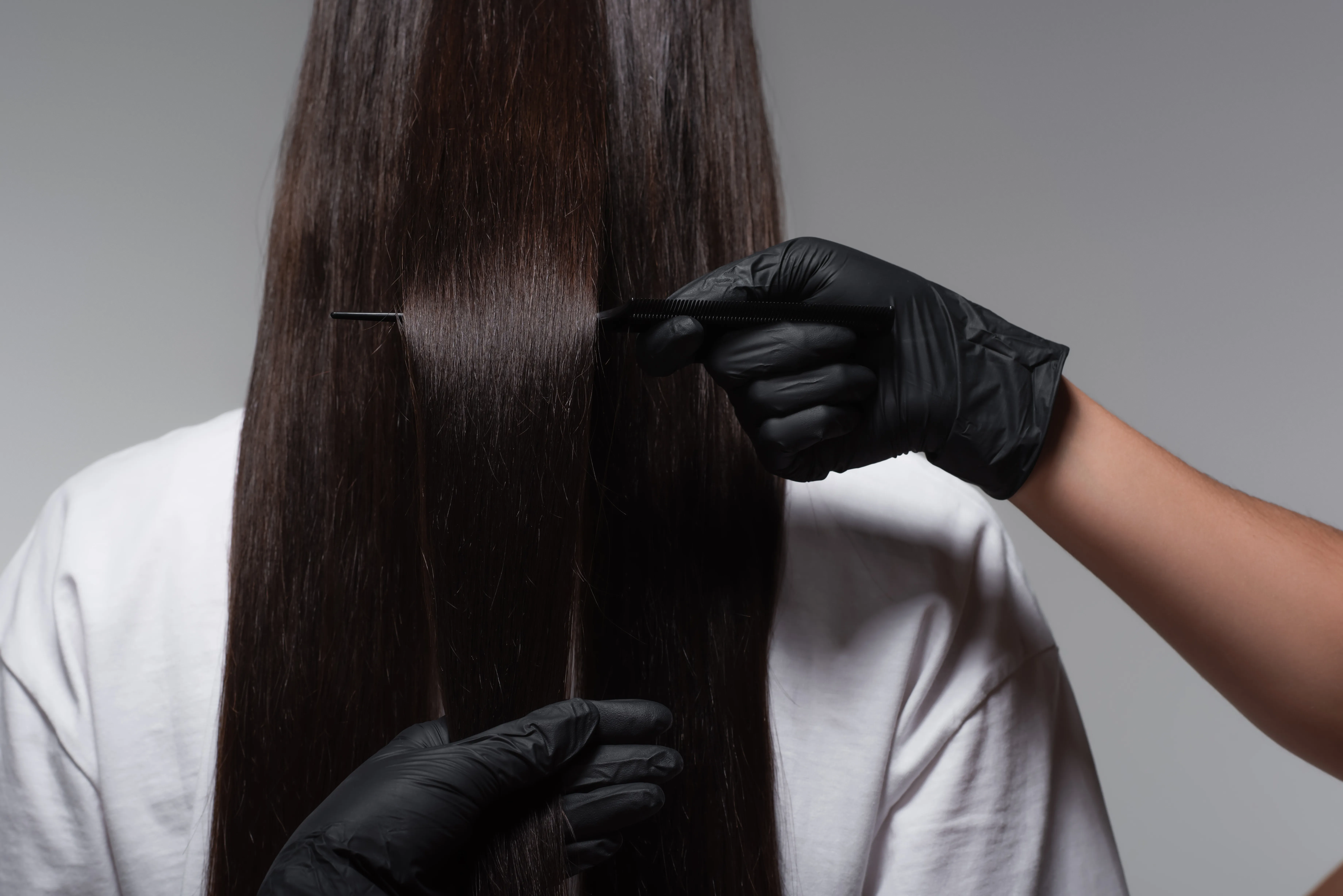 Detailaufnahme: präzises Schneiden mit Kamm und schwarzen Handschuhen